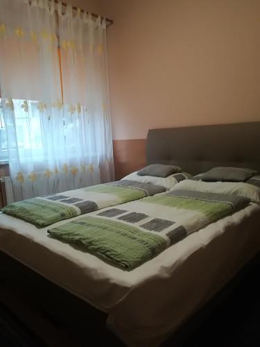 two beds sitting next to each other in a bedroom at Vár-Liget Vendégház in Kisnána