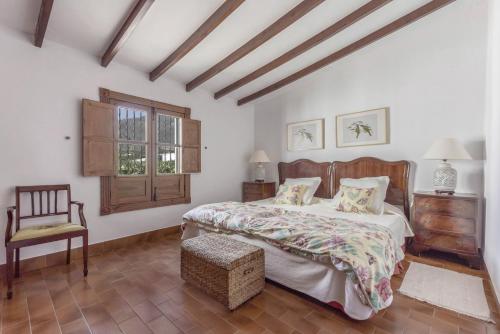 een slaapkamer met een bed, een stoel en een raam bij La Casita de Los Orovales in Puerto de la Cruz