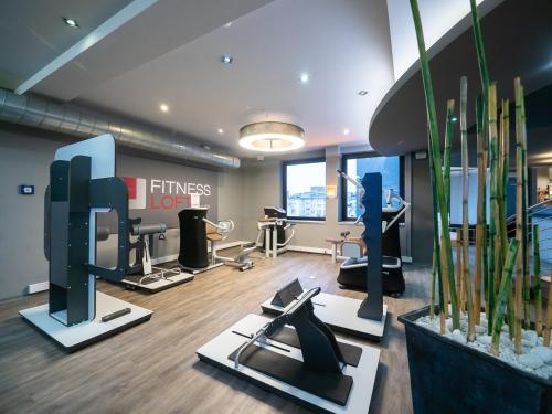 a fitness room with treadmills and exercise equipment at Domaine Leidinger in Saarbrücken
