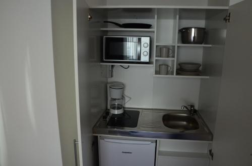 a small kitchen with a microwave and a sink at Gasthaus Löwen in Unterreichenbach