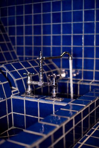 a blue tiled bathroom counter with a blue sink at Hotell Gästis in Varberg