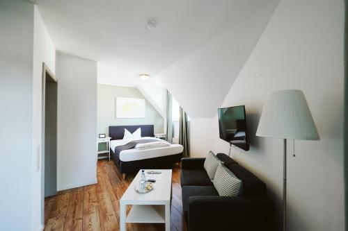 a living room with a couch and a bed at Hotel Grüner Baum in Hamm