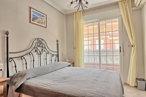 ein Schlafzimmer mit einem Bett und einem großen Fenster in der Unterkunft 023 - Puerto Arrecife II 001 - comfortHOLIDAYS in Santa Pola