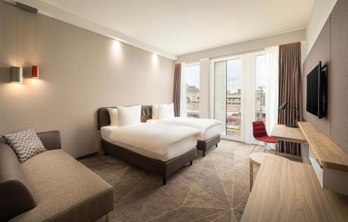 a hotel room with two beds and a couch at Holiday Inn - Mannheim City - Hauptbahnhof, an IHG Hotel in Mannheim