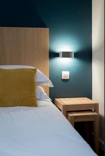 une chambre avec un lit et une table avec une lampe dans l'établissement Hotel Mirabeau Eiffel, à Paris