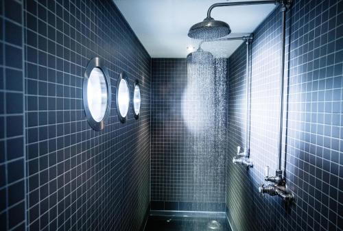 a bathroom with a shower stall and a mirror at Hotel Du Vin Newcastle in Newcastle upon Tyne
