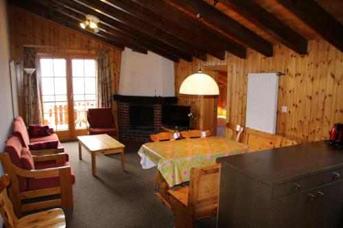 ein Wohnzimmer mit einem Tisch und einem Kamin in der Unterkunft Mayens de l'Ours MOUNTAIN & CENTER apartments by Alpvision Résidences in Agettes