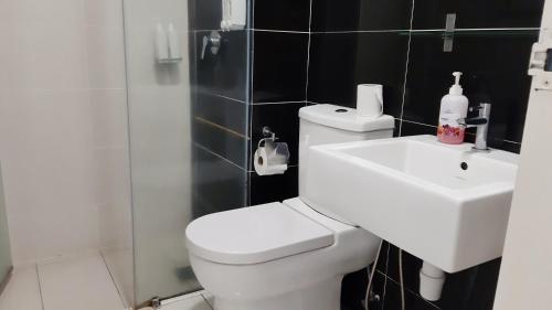 a bathroom with a white toilet and a sink at No.11 The John @ Puchong Skypod Residence in Puchong