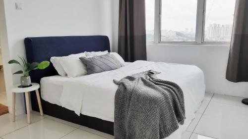 een bed met witte lakens en kussens in een slaapkamer bij No.11 The John @ Puchong Skypod Residence in Puchong