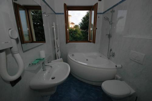 a bathroom with a sink, toilet and bathtub at Hotel Ristorante San Carlo in Arona