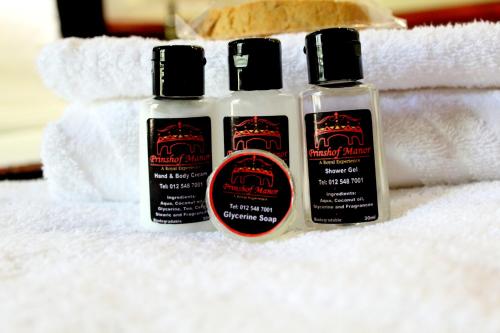 three bottles of hair products sitting on a towel at Prinshof Manor Guesthouse in Pretoria