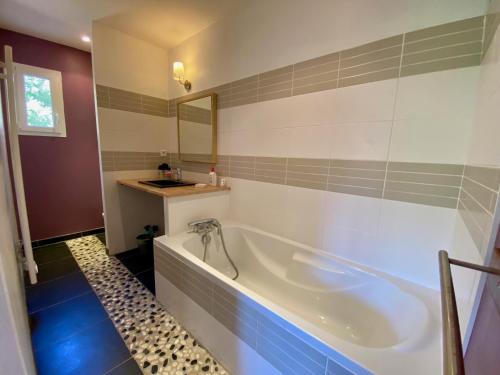 une salle de bain avec une baignoire blanche et un lavabo dans l'établissement Villa les Mimosas with pool and fantastic views, à Lacanau