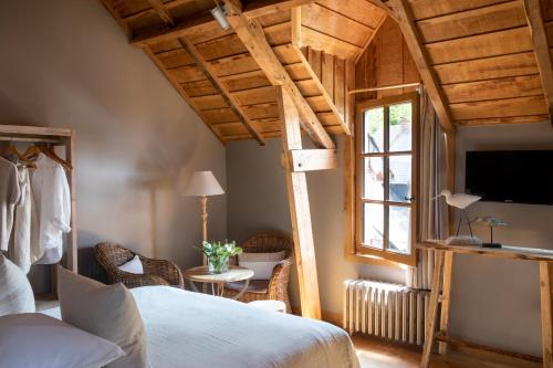 A bed or beds in a room at Auberge de la Source - Hôtel de Charme, Collection Saint-Siméon