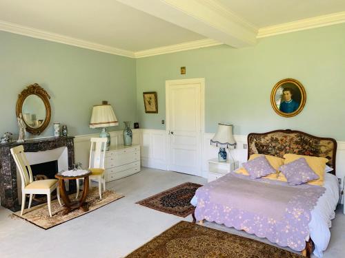 a bedroom with a bed and a table and a mirror at Manoir de Trégaray in Sixt-sur-Aff