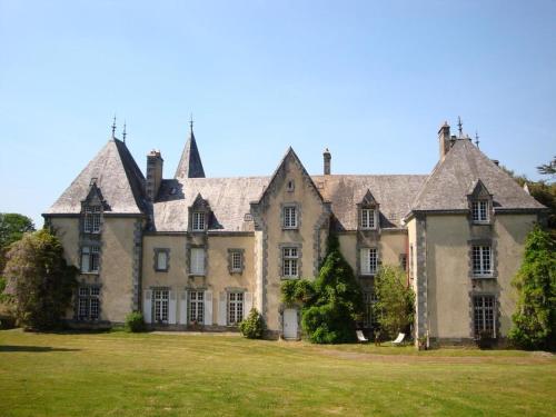 ein altes Herrenhaus mit einem großen Grasfeld in der Unterkunft Manoir de Trégaray in Sixt-sur-Aff