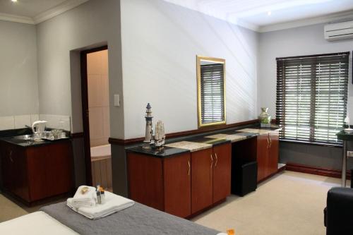a large kitchen with wooden cabinets and a sink at Prinshof Manor Guesthouse in Pretoria