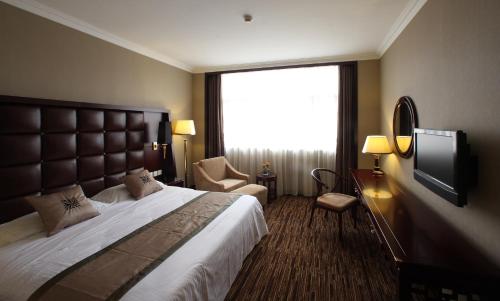 a hotel room with a large bed and a television at Jianguo Qianmen Beijing in Beijing