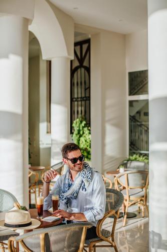 a man sitting at a table at a table at Louis Paphos Breeze in Paphos City