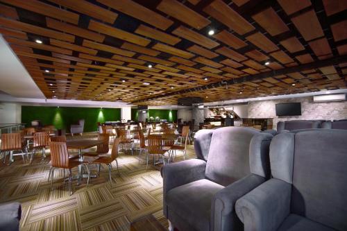 a restaurant with couches and tables and a bar at favehotel Graha Agung Surabaya in Surabaya