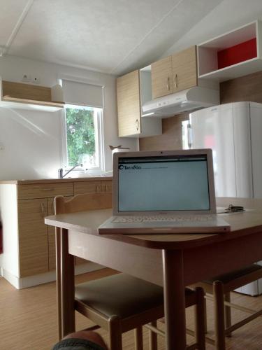 un ordinateur portable assis sur une table dans une cuisine dans l'établissement La Caillebotière, à La Barre-de-Monts