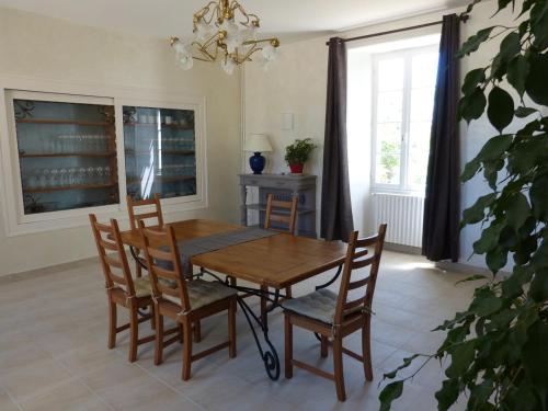 uma sala de jantar com uma mesa de madeira e cadeiras em Domaine de l'Estuaire em Saint-Thomas-de-Cônac