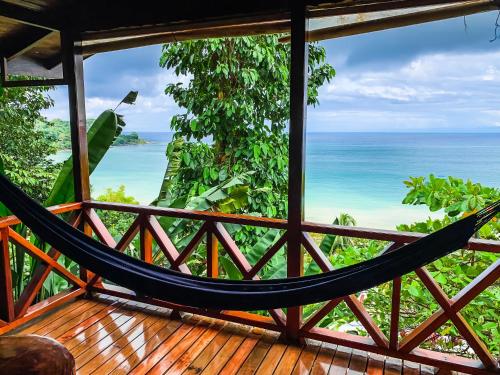 a hammock on a porch overlooking the ocean at Las Cotingas Ocean View in Drake