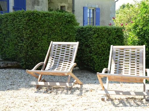 two chairs sitting on the sand in front of a house at Chambres d'Hôtes La Sauvageonne in Saint-Palais
