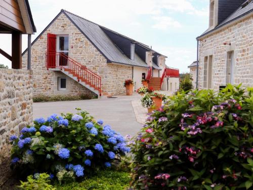 een stenen huis met bloemen ervoor bij La Ferme de Vur Ven in Saint-Évarzec