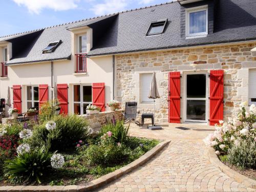een huis met rode deuren en een patio bij La Ferme de Vur Ven in Saint-Évarzec