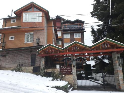 a large building with a gazebo in the snow at Ruca Cheli Village Ski Hotel in San Carlos de Bariloche