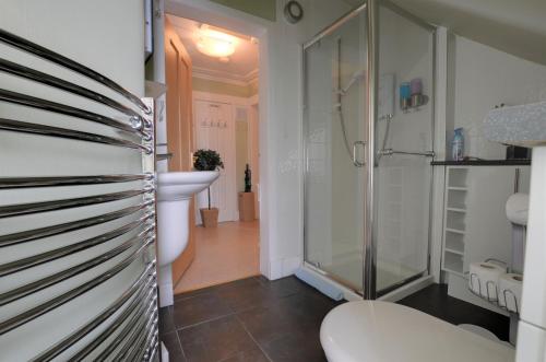 a bathroom with a shower and a toilet and a sink at King Street Apartment in Inverness