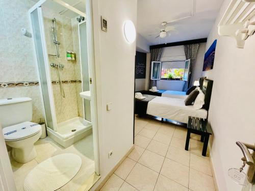 a bedroom with a bed and a bathroom with a toilet at Hostal Lleida in Barcelona