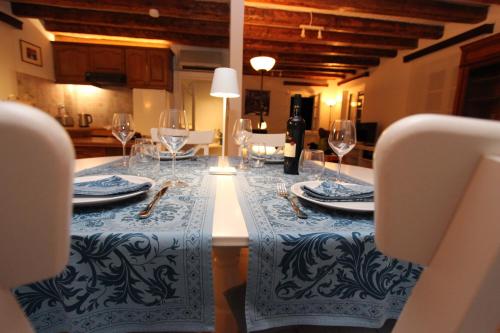 a table with a blue and white table cloth and wine glasses at Lighthouse apartment in Corfu Town