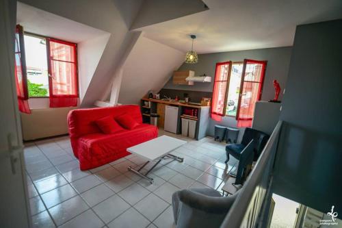 un salon avec un canapé rouge et une table dans l'établissement DUPLEX CENTRE VILLE 6 personnes (WIFI/PARKING), à Troyes