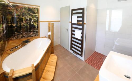 y baño con bañera y lavamanos. en Ferienwohnung Rhönchalet und TBund, en Fladungen