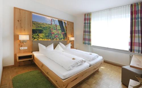 a bedroom with a large bed with a large window at Ferienwohnung Rhönchalet und TBund in Fladungen