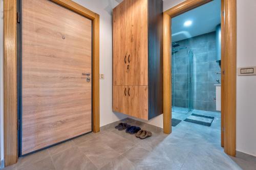 een badkamer met een douche en een houten deur bij Santos Hills Zlatibor in Zlatibor