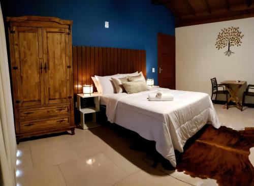 a bedroom with a large bed with a wooden headboard at Pousada Doce Mar in Guarda do Embaú