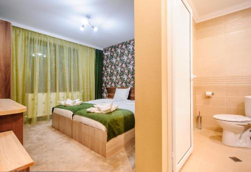 1 dormitorio con 1 cama y baño con aseo en Пиргуля, en Miladinowzi