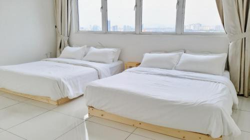 Duas camas num quarto branco com uma janela em No.12 The Heya @ Japanese Style Super Comfort House em Puchong