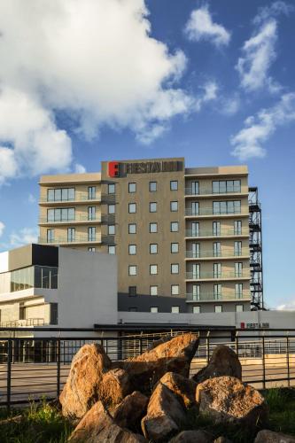 a hotel with rocks in front of a building at Fiesta Inn Guadalajara Aeropuerto in Guadalajara