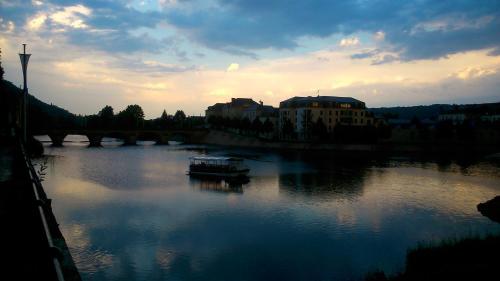 a boat on a river under a bridge at Hôtel Grand Confort Le Moulin Rouge in Terrasson-Lavilledieu