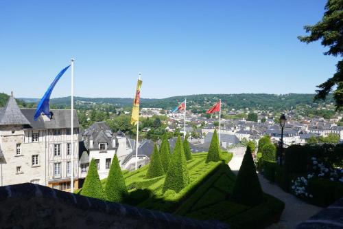 a view of a city with flags and a building at Hôtel Grand Confort Le Moulin Rouge in Terrasson-Lavilledieu
