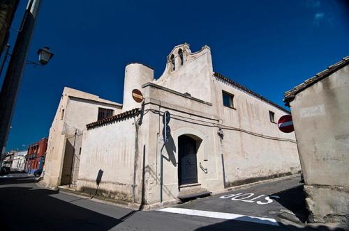 an old white building on a city street at Bed and Breakfast Su Niu in Quartucciu