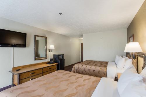 a hotel room with two beds and a television at Quality Inn & Suites Big Stone Gap in Big Stone Gap