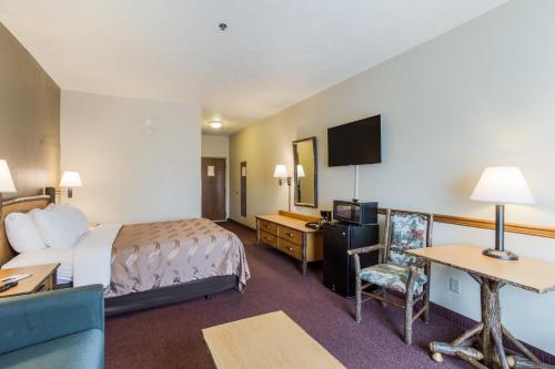 a hotel room with a bed and a television at Quality Inn & Suites Big Stone Gap in Big Stone Gap