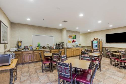 a restaurant with tables and chairs and a tv at Quality Inn & Suites Big Stone Gap in Big Stone Gap
