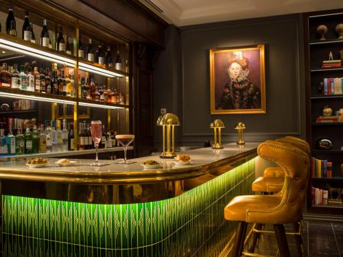 a bar with a green lighting in a restaurant at The Guardsman - Preferred Hotels and Resorts in London