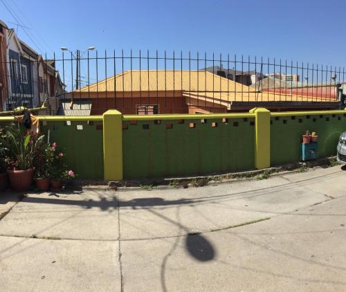 uma cerca verde em frente a um edifício em Casa Barros Borgoño em Valparaíso