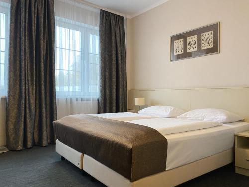 a bedroom with a large bed in front of a window at Hotel Riverside in Kaliningrad